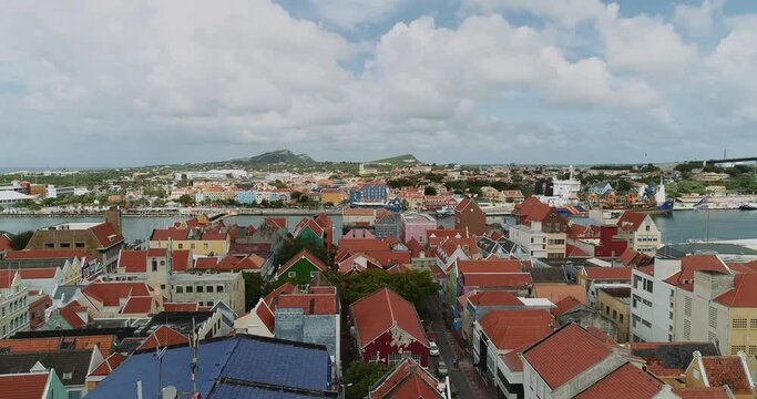 Willemstad is the capital city of Curaçao, a Dutch Caribbean island. aerial view  features brightly painted colonial buildings and colorful roofs. At the back Otrobanda