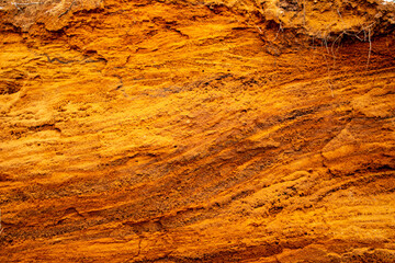 Textural sand, with  relief surface, multi-colored layers and different in size of granules, in outdoor sand career, after mining ore and sand for construction.