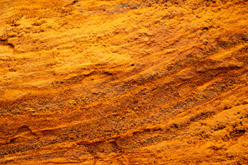 Textural sand, with  relief surface, multi-colored layers and different in size of granules, in outdoor sand career, after mining ore and sand for construction.