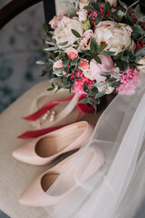 Bouquet, shoes and jewelry of the bride on the chair 3789.