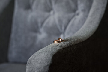 Obraz premium Wedding rings on the armrest of a velour armchair 3901.