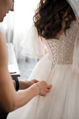 A friend ties a wedding dress on the bride 3982.