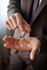 Two gold wedding rings in mens hands 4130.