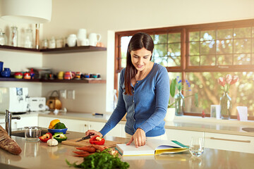 Trying an exciting new recipe. Shot of an attractive young woman preparing a meal in her kitchen.