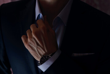 young man in suit adjusting his collar
