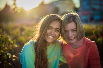 Two smiling girls. Two friends. Happy female students having fun together. Two young girls in the evening outside