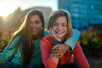 Two smiling girls. Two friends. Happy female students having fun together. Two young girls in the evening outside
