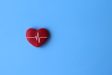 Top view image of red heart and heartbeat line on blue background with copy space for text.