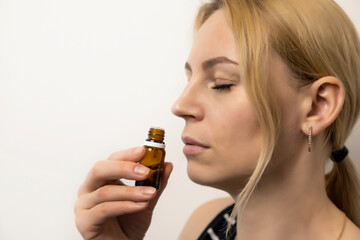 Relaxation, aromatherapy. Young girl sniffs essential oil.