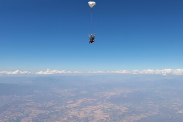 Skydiving. Tandem jump. The falling in the blue sky.