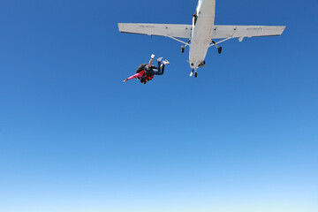 Fototapeta na wymiar Skydiving. Tandem jump. The falling in the blue sky.