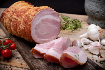 Smoked rolled bacon, roulade, rolled pancetta on wooden boards. Rustic composition with Polish cold...