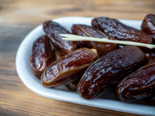 Juicy dates in a package with a wooden fork.