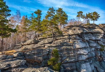 Stone wall with trees against the sky in autumn