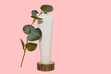 Mockup white container and eucalyptus branch. On a pink background.