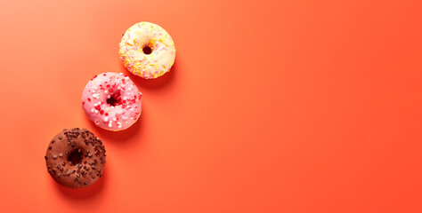 colorful donuts on orange background. Copy space