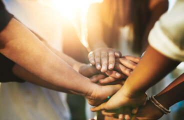 Team support. Cropped shot of an unrecognizable group of people putting their hands together in...