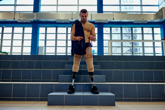 Young adult man with artificial legs standing in the sport center - Powered by Adobe