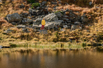 The reflection of a man in a lake, a wild lake in the Carpathians and the reflection of a woman in the water, the reflection of a man in the water.