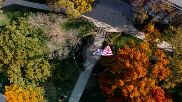 4K Drone Circling Shot Of American Flag Blowing In Wind On Wichita State University Campus In Kansas