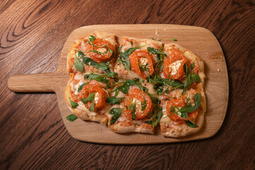 Pizza with salmon on roman dough with ruccola