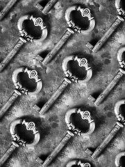 black and white old rusty keys on concrete background. Pattern of rustic old keys