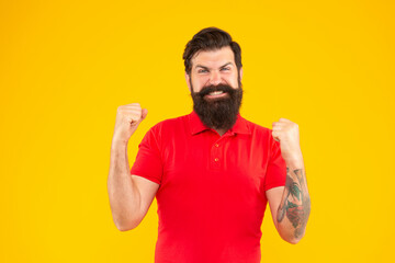 successful bearded man with moustache in tshirt on yellow background, success