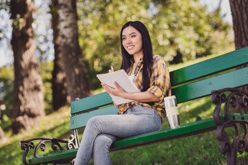 Obraz premium Photo of pretty cute young woman dressed plaid shirt sitting bench writing copybook smiling outside countryside nature