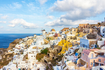 houses and windmills in the city of Thira, Santorini, Greek Islands. In the background the Aegean Sea