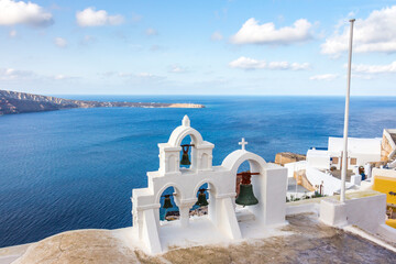 bells in the city of Thira, Santorini, Greek Islands. In the background the Aegean Sea