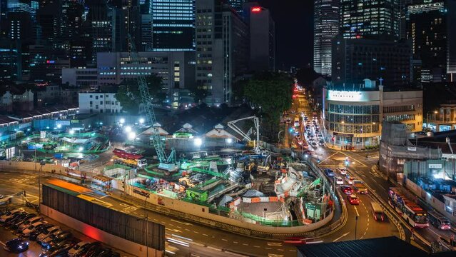 Night timelapse view of traffic around construction site in the Chinatown district of Singapore, rapid development and population growth concept. 