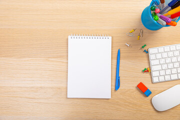 Working table with keyboard and notepad, pen, pencil and plant in home office. top view