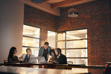 Technology brings colleagues together. Shot of a group of designers having a brainstorming session...