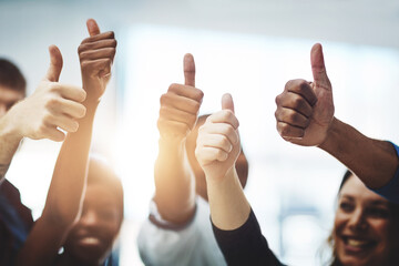 Bravo on your business accomplishment. Cropped shot of a team of colleagues showing thumbs up at...