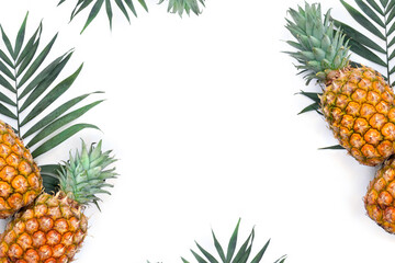 Fresh tropic fruit pineapples and leaf palm tree on white background with space for text. Top view, flat lay