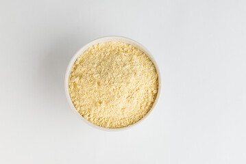 Chickpea flour in white plate on white background, top view