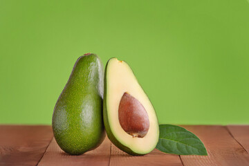 avocado on wooden and green background