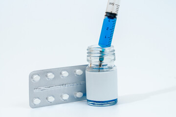 Medical glass bottle with syringe and tablets (pills) isolated on white background