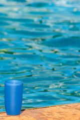 Fototapeta na wymiar blue plastic cup on the edge of a swimming pool in Brazil