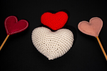 corações em crochê e feltro, nas cores branco, vermelho, vinho e rose, em fundo preto