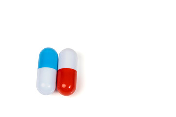 Two pills isolated on white background. Blue and red capsules. Medical concept. The issue of drug choice. Copy space.