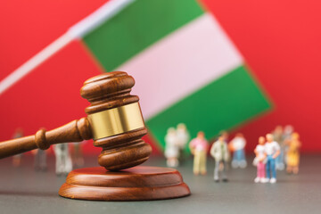 Judge gavel, flag of Nigeria and plastic toy men on colored background, concept of litigation in...