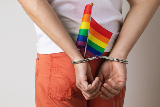 A man in handcuffs with an LGBT flag in his jeans pocket, a concept on the topic of violation of the rights of LGBT minorities and oppression in different countries