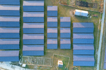 Aerial view of large sustainable electrical power plant with rows of solar photovoltaic panels for producing clean ecological electric energy. Renewable electricity with zero emission concept.