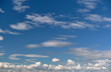 Bright landscape of white puffy cumulus clouds on blue clear sky