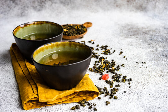 Two cups of Green sencha tea with dried mango