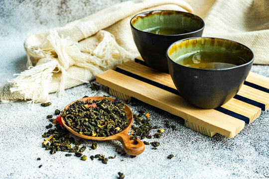 Two cups of Green sencha tea with dried mango