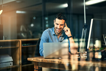 Inspiring productivity with a wealth of technology. Shot of a young businessman talking on his...