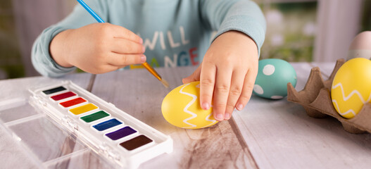 Boy dying painting Easter eggs 