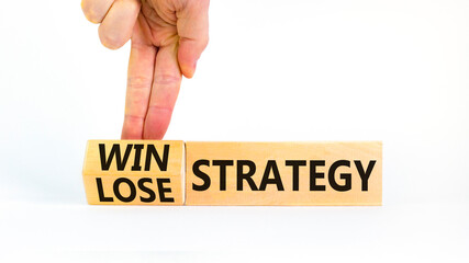 Win-lose strategy symbol. Businessman turns wooden cubes and changes words lose strategy to win strategy. Beautiful white table, white background. Business, win-lose strategy concept. Copy space.